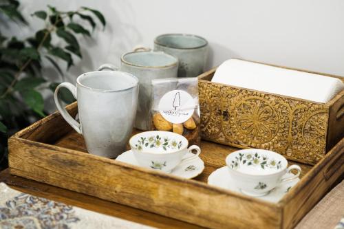 a wooden tray with tea cups and a box at Locanda Vecchio Cipresso in Chiaverano