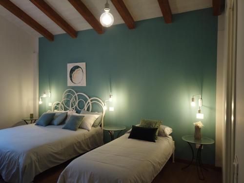 a bedroom with two beds and a blue wall at Il Mandorlo in Amantea
