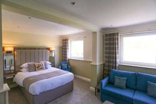 a bedroom with a bed and a blue couch at Duck Bay Hotel & Restaurant in Balloch