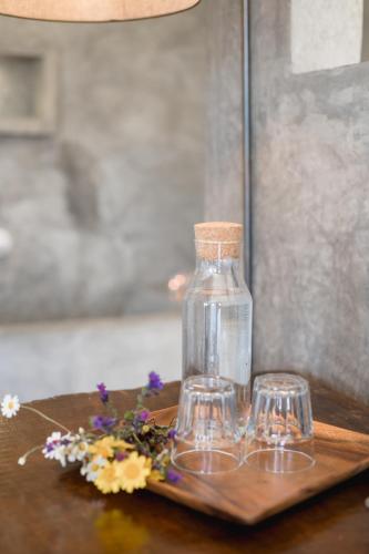a glass bottle and two glasses on a wooden table at Monte Gois Country House e Spa in Curvatos