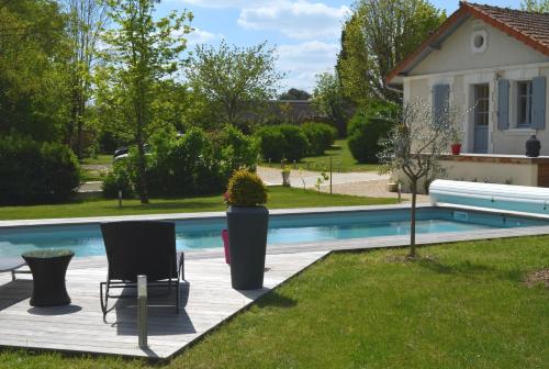 une piscine avec deux chaises à côté d'une maison dans l'établissement Le Bataclan, à Balzac