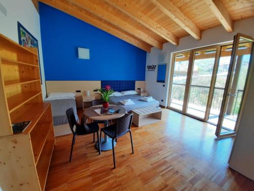 a room with a table and chairs and a blue wall at Agriturismo Terra del Sole in Albosaggia