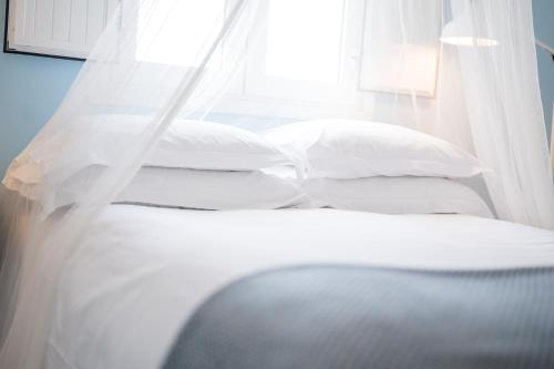 two beds with white sheets and pillows in a room at Monte Gois Country House e Spa in Curvatos