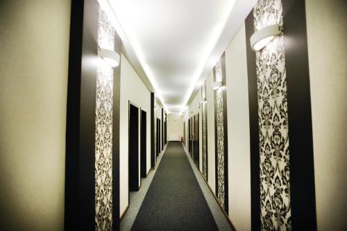 a hallway with black and white paintings on the walls at Hotel Dębowe Wzgórze Wellness & Spa in Jarnołtówek