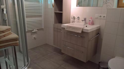 a white bathroom with a sink and a shower at Zauscherhof in Wildermieming