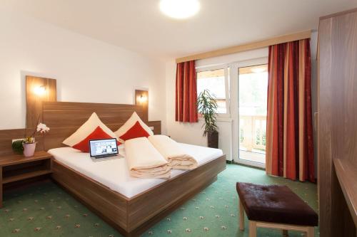 a bedroom with a bed with a laptop on it at Apart Reich in Längenfeld