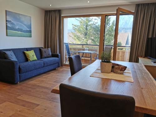 a living room with a table and a blue couch at Zauscherhof in Wildermieming