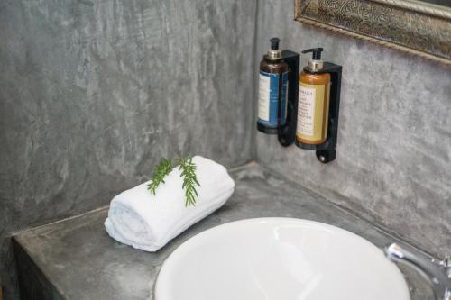 a bathroom with a sink and a toilet with a towel at Monte Gois Country House e Spa in Curvatos
