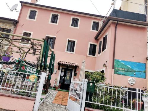 a pink house with a gate in front of it at Art B&B La Casa del Pittore in Revine Lago