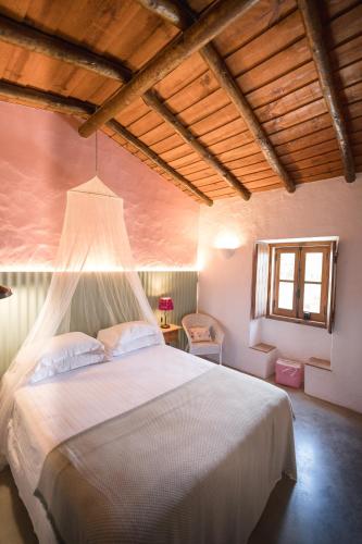 a bedroom with a large white bed in a room at Monte Gois Country House e Spa in Curvatos