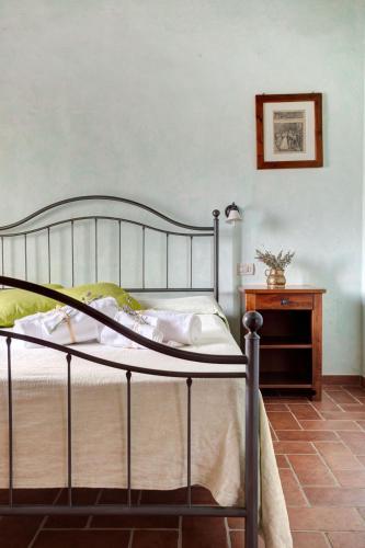 a bedroom with a metal bed and a table at Fattoria Fibbiano in Terricciola