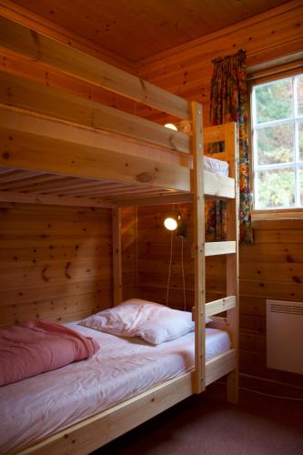 a bedroom with two bunk beds in a log cabin at Hjelledalen Hyttesenter in Hjelle