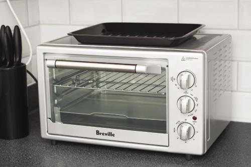 a toaster oven with a tray on top of it at Rustling Oaks NZ Boho Pool House in Cambridge