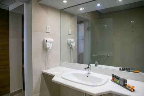 La salle de bains est pourvue d'un lavabo et d'un téléphone mural. dans l'établissement Almyra Hotel & Village, à Koutsounari