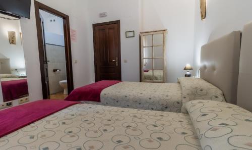 two beds in a room with a bathroom at Hotel Rural VII Carreras by Vivere Stays in San Pedro de Rozados