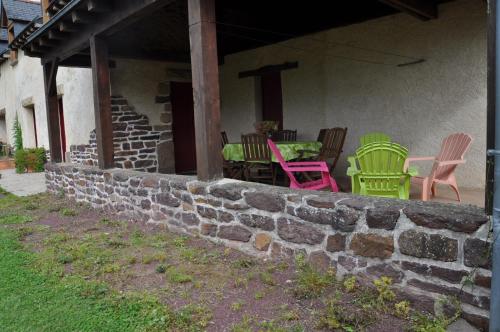 a group of chairs and tables on a stone wall at La Demeure de Merlin l'Enchanteur in Loscouët-sur-Meu