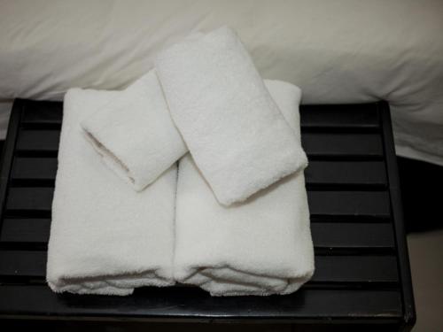 a pile of white towels sitting on a bed at Dunwoodie Travel Lodge in Pretoria