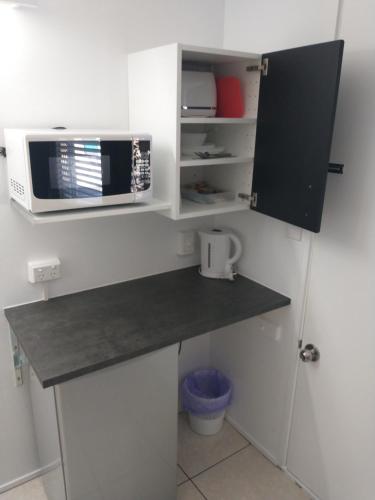 a kitchen with a counter top with a microwave at Aspley Sunset Motel in Brisbane