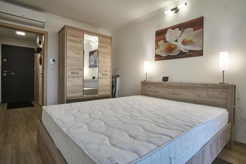 a bedroom with a large bed in a room at Cadet Apartments - hostAID in Siófok