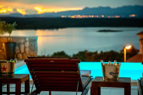 a chair and a table with a view of the water at Luxury Villa Allen with Pool in Klimno