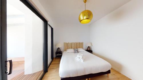 une chambre avec un lit blanc et une grande fenêtre dans l'établissement La Bonne Brise - Superbe loft avec terrasse à 2 minutes de la plage, à Marseille