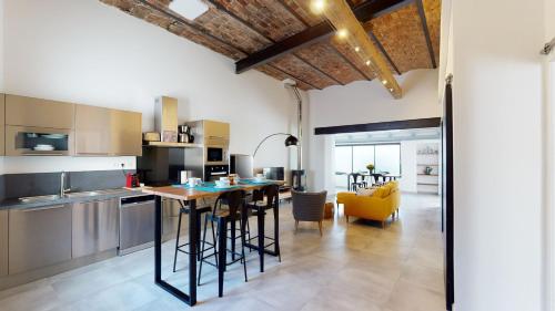 une cuisine avec une table et des chaises dans une pièce dans l'établissement La Bonne Brise - Superbe loft avec terrasse à 2 minutes de la plage, à Marseille