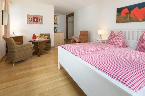 sypialnia z łóżkiem z czerwonym i białym kocem szachowym w obiekcie Feldmann-Schütte w mieście Schmallenberg