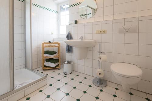 een badkamer met een toilet, een wastafel en een bad bij Feldmann-Schütte in Schmallenberg