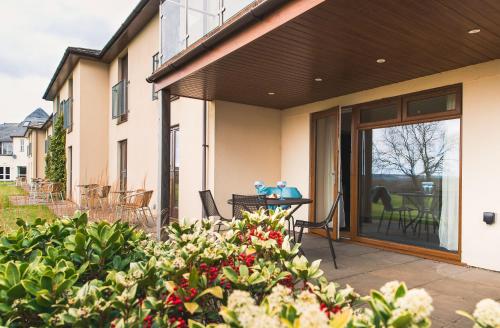 a house with a patio with a sliding glass door at Lanhydrock Hotel & Golf Club in Bodmin