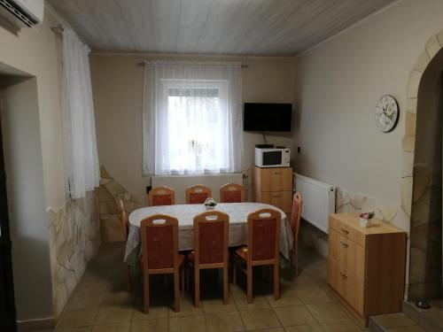 a kitchen with a table and chairs in a room at Napraforgó Vendégház in Mezőkövesd