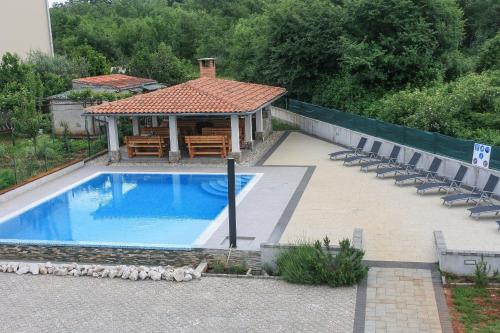 een zwembad met stoelen en een prieel bij Apartment Suzy in Vantačići