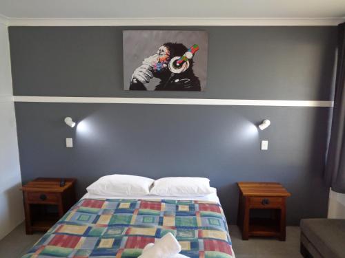 a bedroom with a bed with a painting on the wall at Aspley Sunset Motel in Brisbane