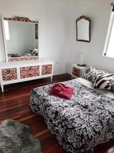 1 dormitorio con cama y espejo en Kyogle Comfy Homestay, en Kyogle