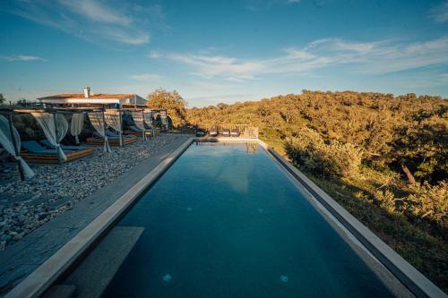 a swimming pool with chairs and a house at Monte Gois Country House e Spa in Curvatos