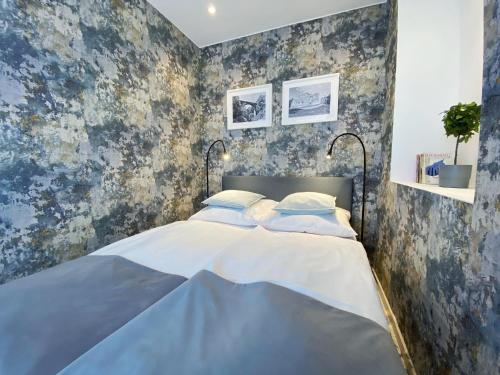 a bedroom with a large bed with blue wallpaper at Hotel Srebrna Góra in Srebrna Góra