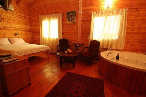 a bedroom with a bed and a tub in a cabin at Amirim Atmosphere in Amirim