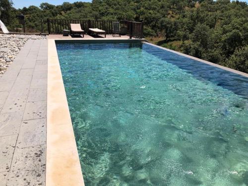 a swimming pool with clear blue water in a backyard at Monte Gois Country House e Spa in Curvatos