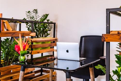 a desk with a laptop computer on a chair at In the Shade Hotel - Coworking - 300Mbit - Adults Only in Tamarindo