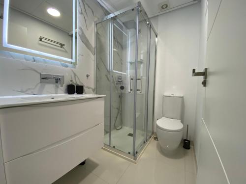 bagno bianco con doccia e servizi igienici di Bianca Beach 212 - cosy flat 250m from Mil Palmeras beach a La Horadada