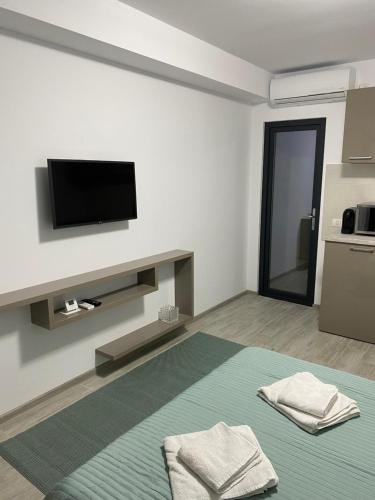 Dieses weiße Zimmer verfügt über ein Bett und einen Flachbild-TV. in der Unterkunft Studio Ra Mamaia-Nord in Mamaia Nord – Năvodari
