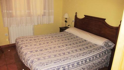 a bedroom with a bed with a wooden head board at Apartaments la Fabrica in Horta de San Joan
