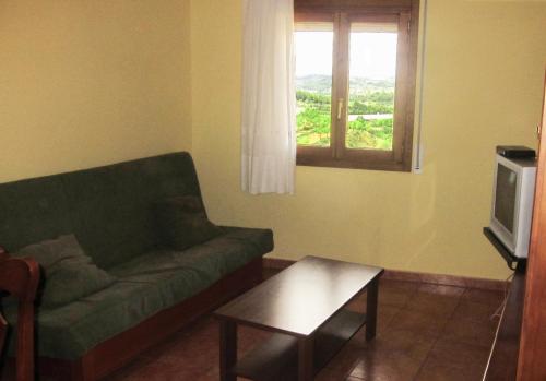 a living room with a couch and a table and a window at Apartaments la Fabrica in Horta de San Joan