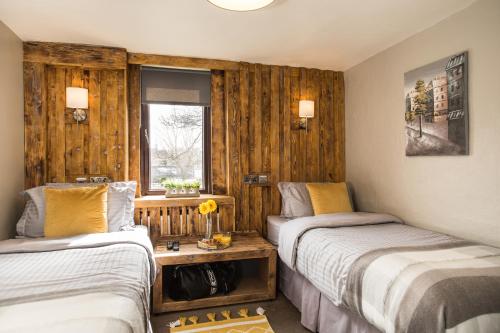 Duas camas num quarto com paredes de madeira em Tipperary House Dublin em Dublin