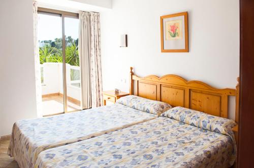 a bedroom with a bed and a large window at Apartamento Playa Dor 17 in Cala d´Or