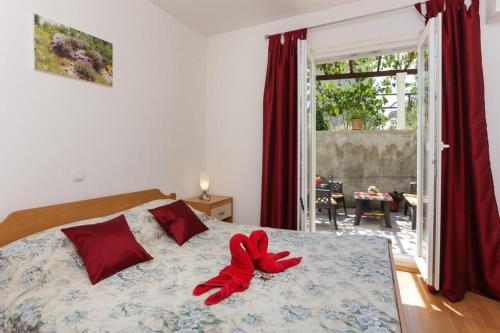 a bedroom with a bed with a red ribbon on it at Apartments Pojko in Dubrovnik