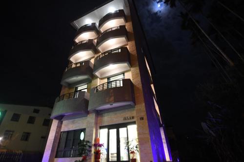 a building with balconies on the side of it at night at 巧人文旅民宿 in Yuchi