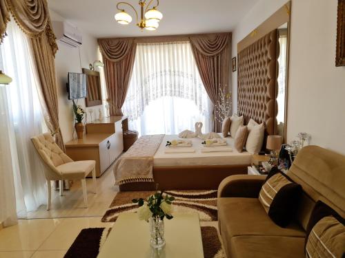 a bedroom with a bed and a living room with a couch at Hotel Dalia - Bankya in Bankya