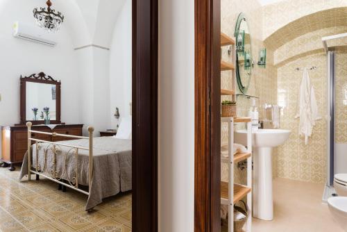 Habitación con baño con cama y lavabo. en Casa Vintage con terrazza by Wonderful Italy, en Ostuni
