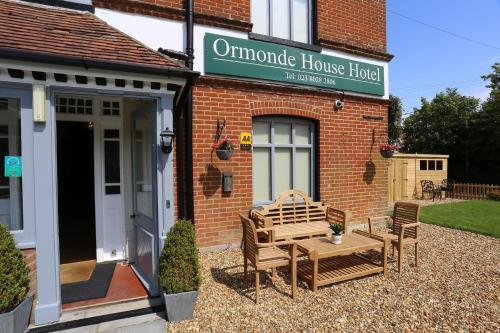 - un bâtiment avec une table et des chaises à l'extérieur dans l'établissement Ormonde House Hotel, à Lyndhurst