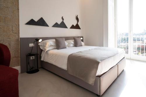 um quarto com uma cama grande e uma janela grande em Ciao Bellini em Nápoles